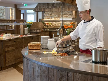 Cuisinier préparant un œuf au buffet petit déjeuner de l'Enztalhotel