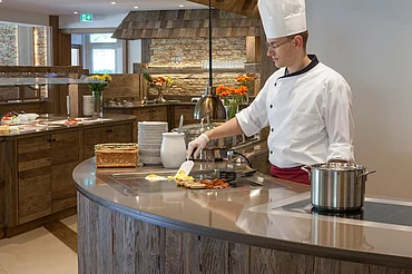 Koch beim Zubereiten von einem Ei im Frühstücksbuffet im Enztalhotel