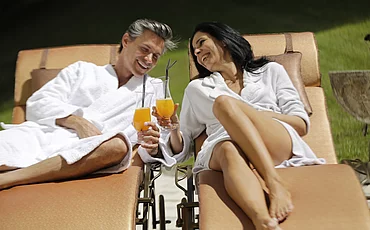 Paar beim Cocktailtrinken im Garten vom Wellnesshotel Enztalhotel 