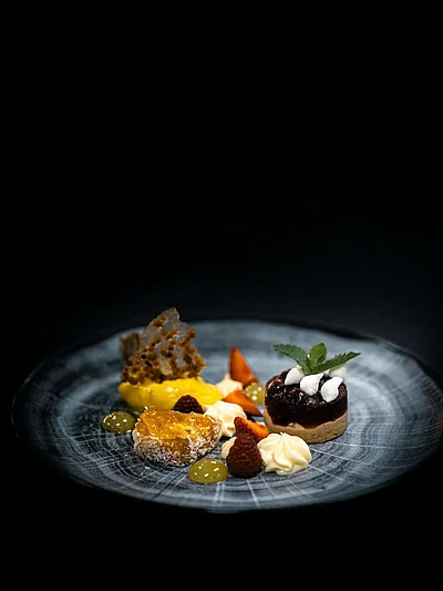 Aus unserer Pâtisserie Nougat-Sauerkirsch-Törtchen mit Aprikosensülze, feiner Kokoscreme und erfrischendem Passionsfrucht-Sorbet
